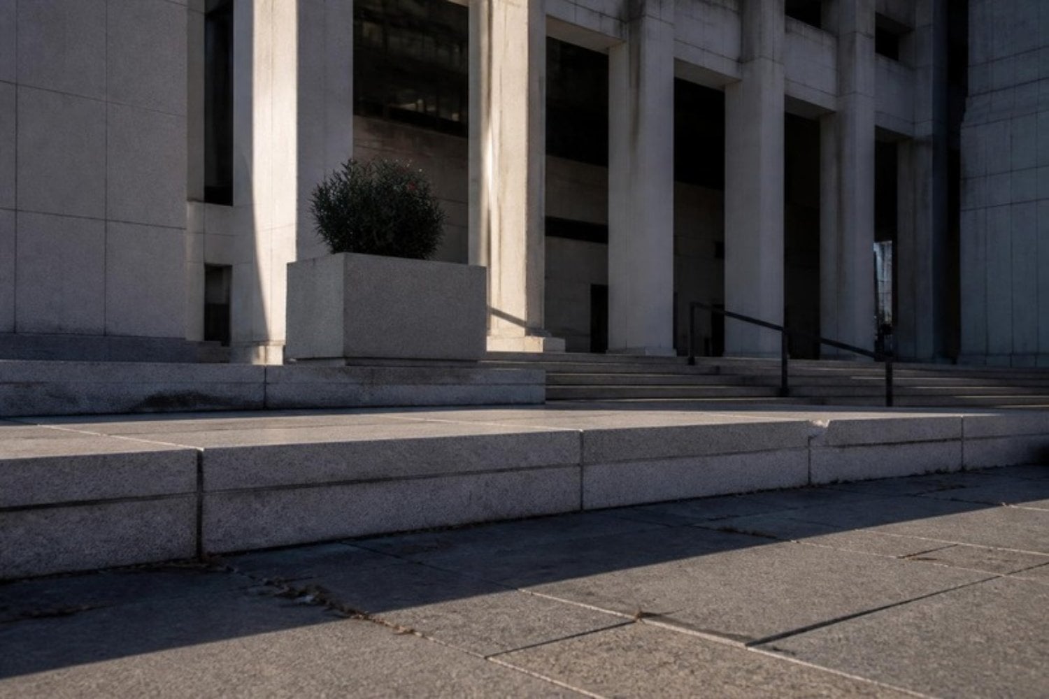The exterior steps of a Houston criminal courthouse in the early morning, long shadows