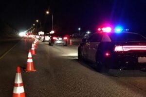Police car and traffic cones at a nighttime DWI checkpoint