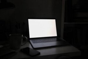 Laptop glowing on a desk at night