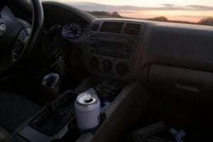 Open beer can in a car cupholder