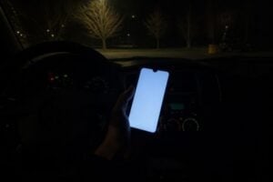 Smartphone glowing in a parked car at night