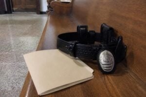 Police duty belt and badge on a courthouse bench