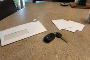 An insurance claim envelope and car keys on a kitchen table