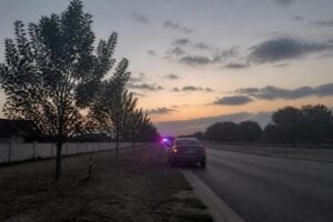 Car stopped by police on a suburban Sugar Land road at dusk